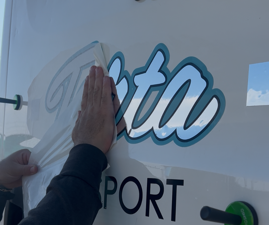 Close-up of a full-color printed company logo being installed on a commercial vehicle.